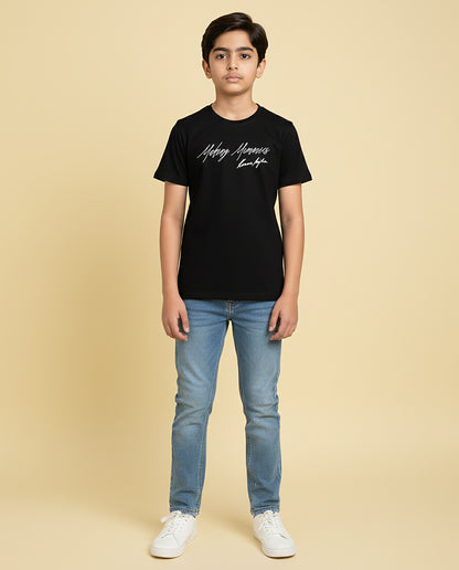 Kid wearing black “Making Memories” Karan Aujla kids unisex T-shirt with signature-style print